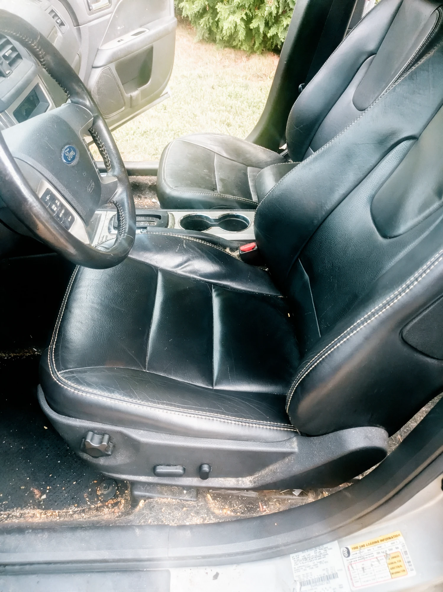 Driver seat before detailing with dirty floor